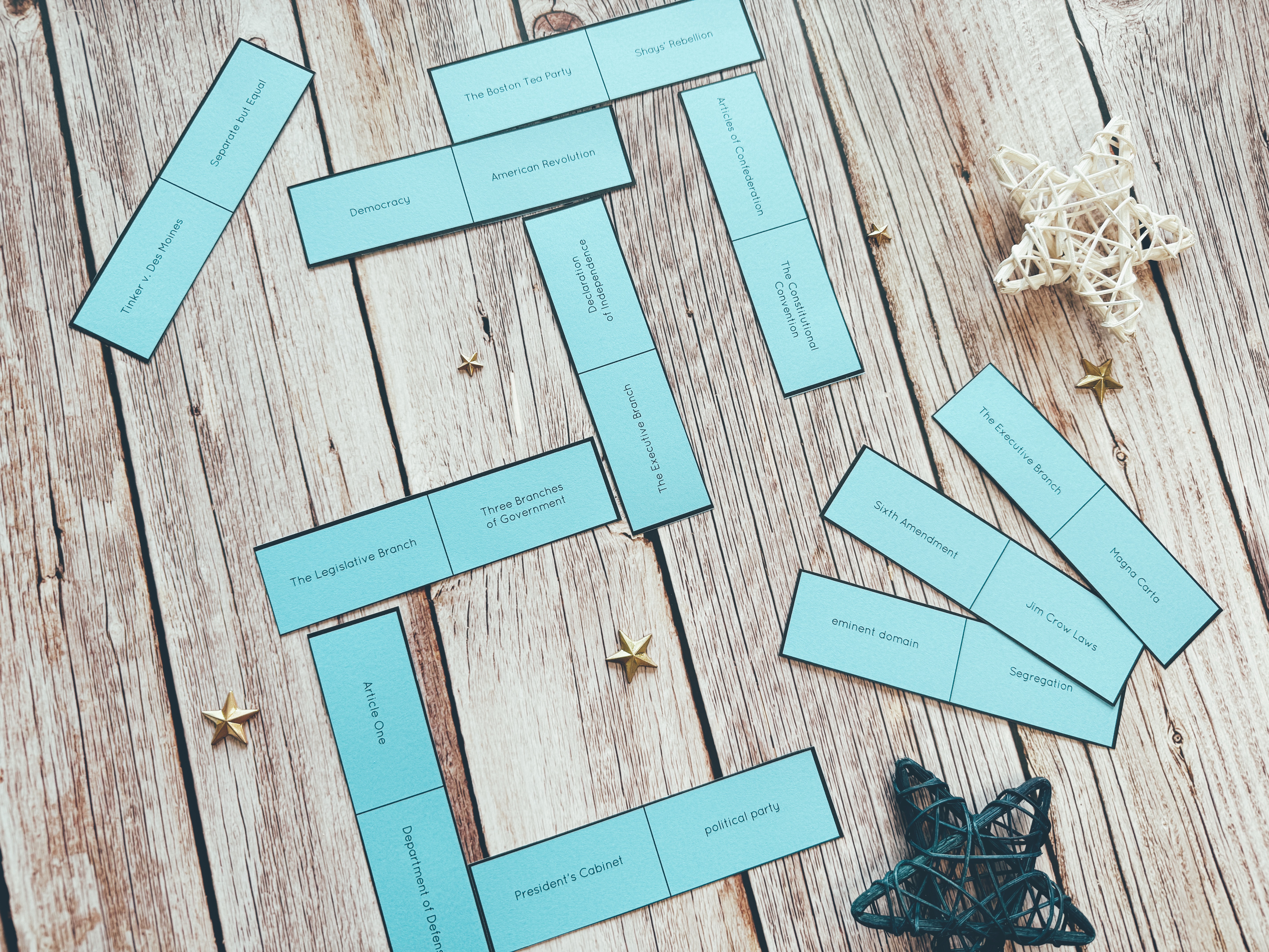 Blue dominoes tiles with Civics-related vocabulary on them, displayed on a table.